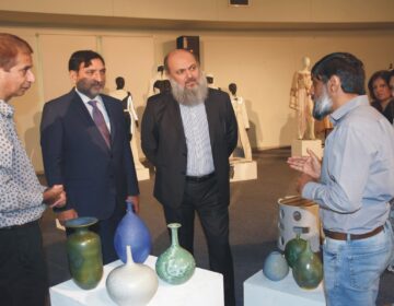Jam Kamal Khan touring Pakistan Institute of Fashion Design, observing student projects in textiles, ceramics, leather, and jewelry.