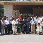 Panel of Pakistani health and policy experts speaking at a Murree press briefing, with a banner on non-communicable diseases and images of sugary drinks and snacks in the background.