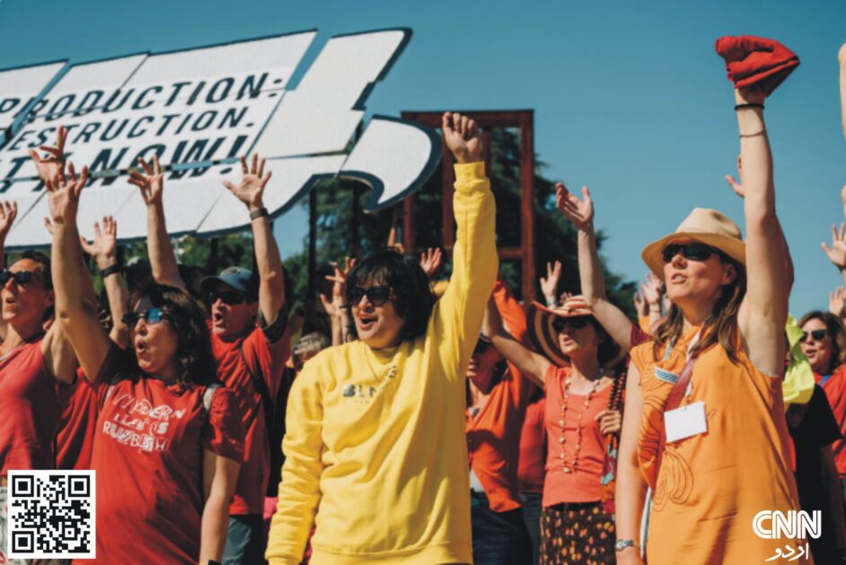 Hundreds of citizens and activists in red, yellow, and orange rally in Geneva to demand a strong plastics treaty before UN negotiations begin.